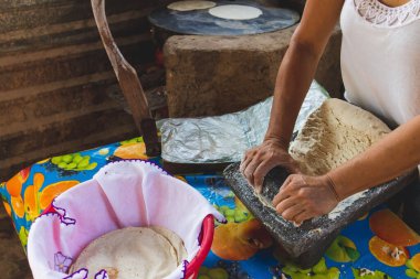 Meksikalı bir kadın, cuautla, jalisco, mex 'te ev yapımı tortilla yapmak için soba ve odun sobasında mısırlara işkence ediyor.