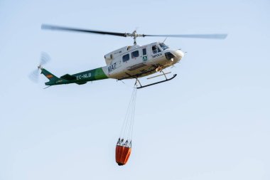 Ronda, Malaga, İspanya 11 Haziran 2022 itfaiye helikopteri havada su torbasını ateşe veriyor.