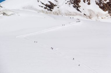 İsviçre 'de karlı bir dağda yürüyen insanların güzel bir manzarası.