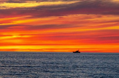 Gün batımında Marthas Vineyard adasında bir koruma teknesinin silüeti.