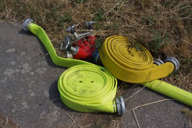 Bir itfaiye istasyonunun hortumları ve su dağıtıcıları yol kenarında uzanıyorlar. Egzersiz ya da sulama, kim bilir.?