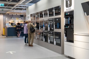 Polonya 'daki IKEA mobilya ve ev aletleri mağazasında fırın sergisine bakan yaşlı bir çift.