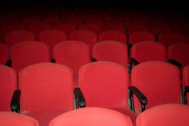 Tiyatroda boş kırmızı sandalyeler. Fotoğraf el feneri kullanılarak çekildi.