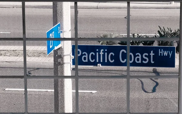 Vägskylt Mot Pacific Coast Bakom Ett Byggnadsfönster Vid Sunset Beach — Stockfoto