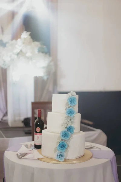 一个用蓝色玫瑰装饰的婚礼蛋糕的垂直照片 — 图库照片