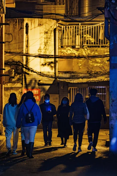 Eine Vertikale Aufnahme Von Menschen Die Nachts Auf Den Straßen — Stockfoto