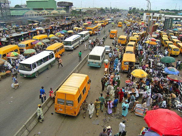 Afrika 'nın en büyük şehri olan Lagos Nijerya' daki işlek otobüs durağında bir sürü market satıcısı ve bir sürü meşgul insan var.