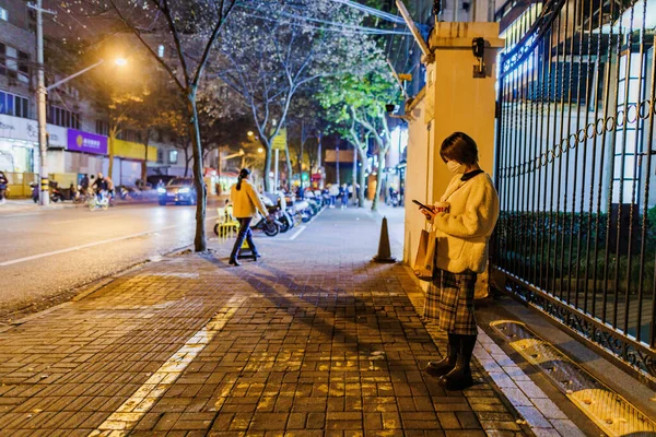 Mladá Žena Stojí Noci Ulici Dívá Telefon Šanghaji — Stock fotografie