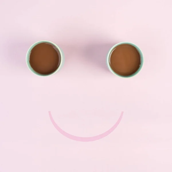 Cup of coffee building the eyes of the funny face, mouth is smiling, wake up in the morning, hot drink with caffeine