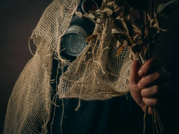 一个戴着防毒面具 用干枯的玫瑰织成的古老面料的男人的照片 美丽的乡村气息 — 图库照片