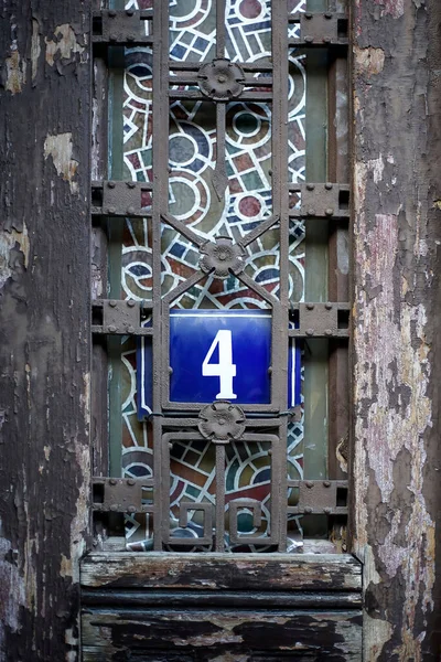 青い金属板の家の番号4 金属装飾の古い木製のドアに — ストック写真