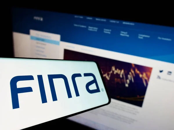 사이트 화면에 Finra 로고가 휴대폰 화면에 집중하 — 스톡 사진