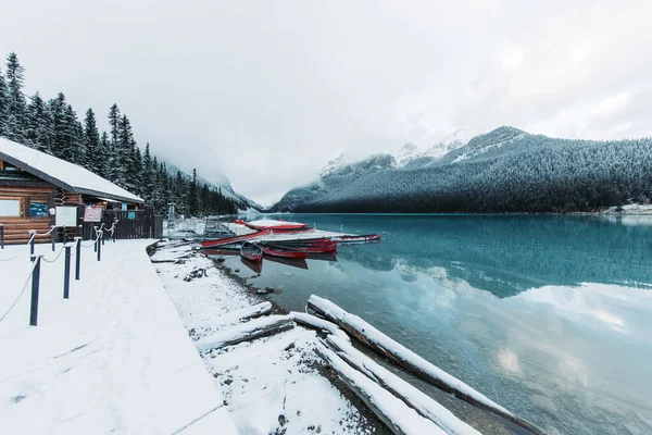 Scenery Icy Lake Louise Red Boats Surrounded Snow Capped Mountains — Stock Photo, Image