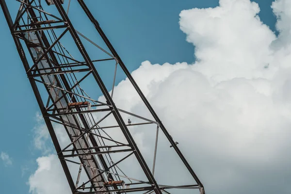 Mavi Bulutlu Arka Planda Demir Vinç Yapısında Oturan Iki Güvercin — Stok fotoğraf