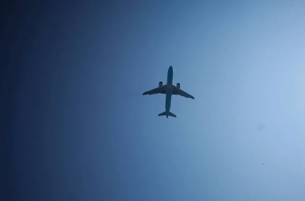 青い空に向かって空を飛ぶ飛行機の低角度ショット — ストック写真