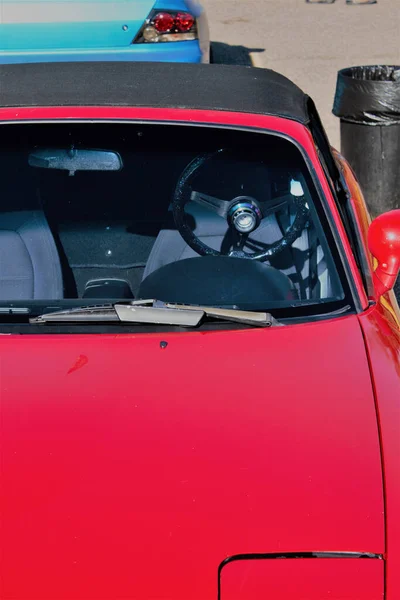 一辆没有司机站在街上的新型红色轿车的垂直镜头 — 图库照片