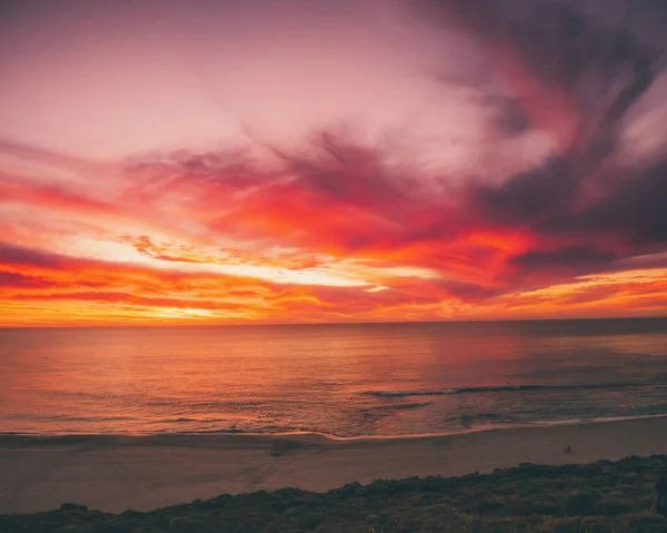 カラフルな曇り空の下でのビーチの美しい夕日 — ストック写真