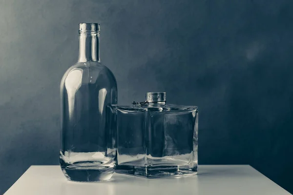 圆形透明玻璃瓶和独特的方形玻璃瓶 用于深色灰色背景的伏特加或白兰地 — 图库照片