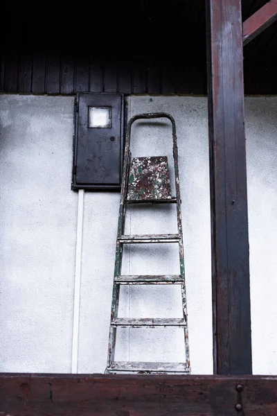 Tiro Vertical Uma Escada Envelhecida Apoiada Uma Parede Branca — Fotografia de Stock
