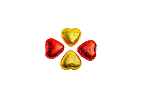 白い背景に金色のハート型のチョコレートと赤いハート型のチョコレートのペア — ストック写真