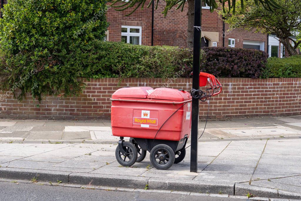 Royal Mail postal delivery worker's trolley locked up on a railing in a suburban street, in Newcastle upon Tyne, UK: June 10th, 2022: