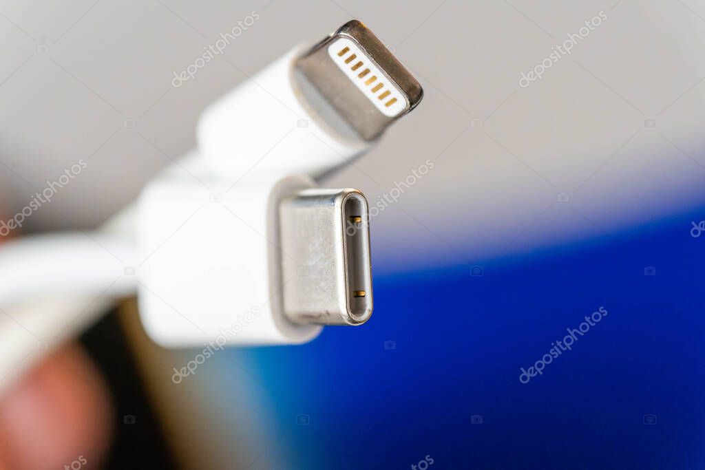 Close up of white USB-C male and Lightning male connectors