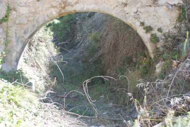 Bir alan yolunun üzerinde kemerli bir yapı