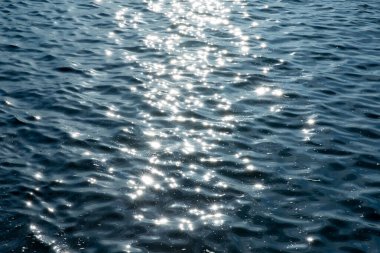 Küçük dalgalarla güzel denizi yansıtan bir güneş ışığı.