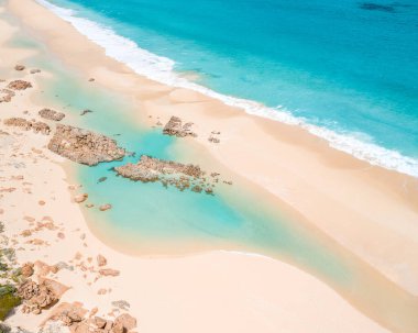 Aydınlık bir günde berrak bir mavi okyanusun büyüleyici görüntüsü.