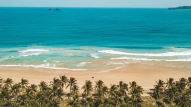 Aydınlık bir günde berrak bir mavi okyanusun büyüleyici görüntüsü.