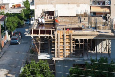 İnşaat işçileri bir ev inşa ediyorlar. Betonu doldurmak için ahşap kalıplar yap. Yunanistan, Volos 6-4-2022