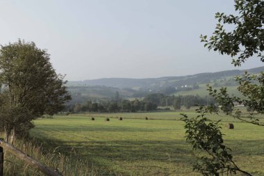 Sauerland, Almanya 'da tepeleri, küçük bir köyü ve tarlaları olan manzaralı bir manzara.