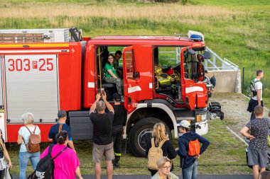 Bir grup ziyaretçi hayvanat bahçesindeki sergi sırasında itfaiye aracının etrafında durup fotoğraf çekiyorlar, Poznan, Polonya