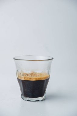 Bir fincan duble espresso. Temiz bir bardakta, üzerinde krema olan beyaz bir kahve.