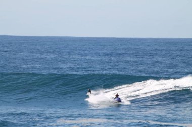 2 Avustralyalı: bir sörfçü ve bir jet ski mükemmel mavi bir günde Avustralya, Sydney yakınlarında Coogee 'de sörf yapıyor..