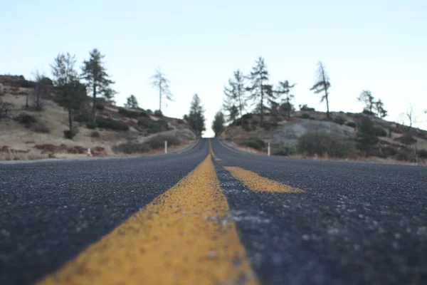 Eine Nahaufnahme Der Straße Mit Gelben Linien Gegen Die Hügel — Stockfoto