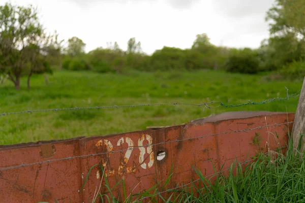 野原の錆びた金属製の柵の閉鎖ショット — ストック写真