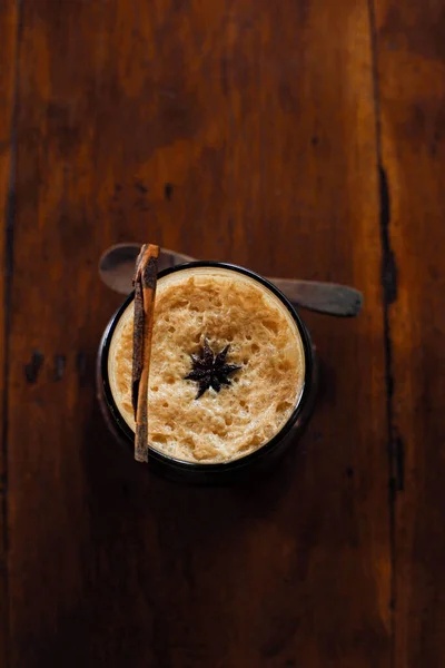 Pionowe Ujęcie Cynamonowego Moktajlu Kawy Zwężonym Brązowym Drewnianym Stole — Zdjęcie stockowe