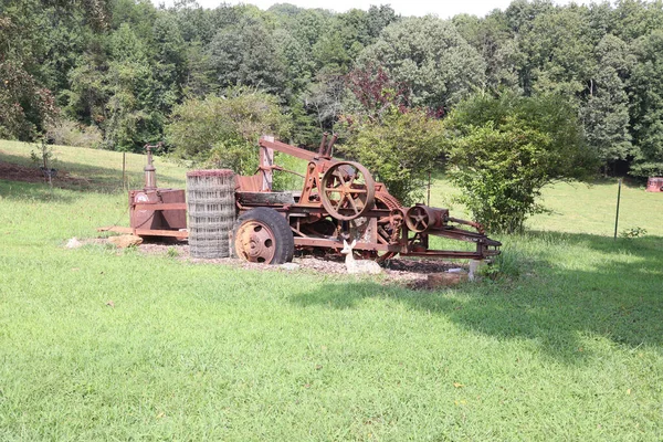 春天的绿地里 一台老旧的农场生锈的机器 — 图库照片