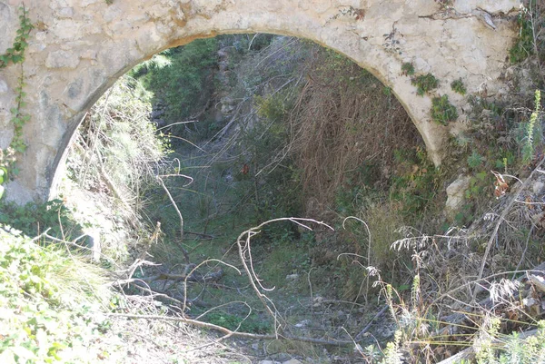 Bir alan yolunun üzerinde kemerli bir yapı