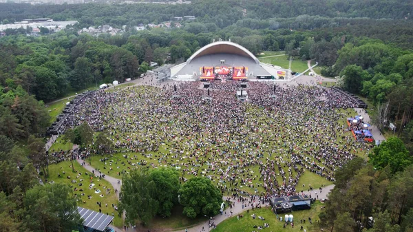 Ogromny Tłum Koncercie Świeżym Powietrzu Dużą Sceną Zielonym Polu Otoczonym — Zdjęcie stockowe