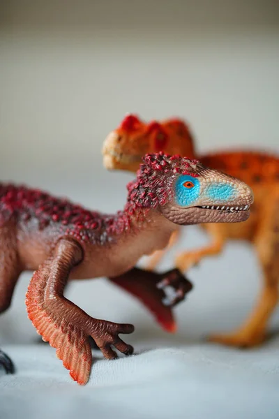 A selective focus shot of Schleich brand utahraptor toy model figurines