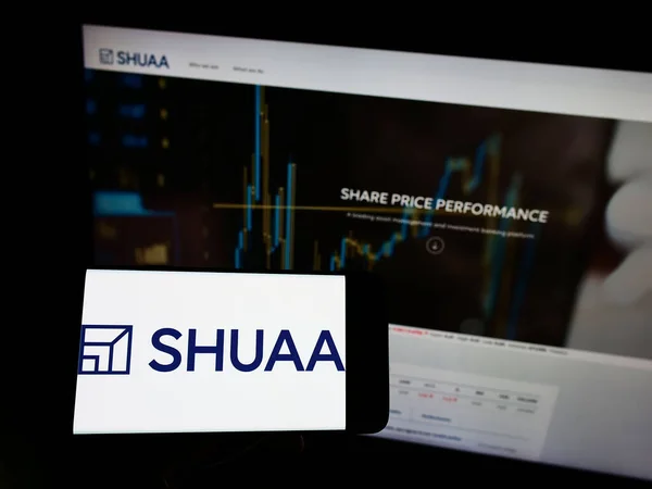 Personne Tenant Smartphone Avec Logo Société Investissement Shuaa Capital Psc — Photo