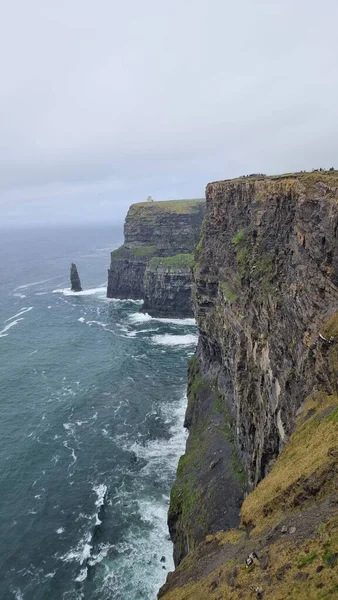 İrlanda 'da kasvetli bir gökyüzünün altındaki Moher Kayalıkları' nın dikey çekimi.
