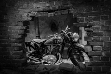 Tuğla duvardaki delikten görünen havalı bir klasik motosiklet..