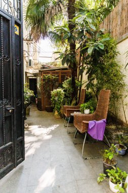 Bir evin arka bahçesinde hasır sandalyelerin dikey görüntüsü.