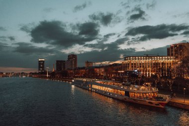 Karanlık gecede suyun yakınındaki modern binaların alçak açılı görüntüsü.