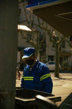 Şangay 'da bir gece sokakta maske takan bir işçi manzarası.