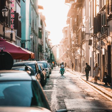 Günbatımında İtalya, Floransa 'nın işlek caddelerinde insanların ve araçların dikey çekimi