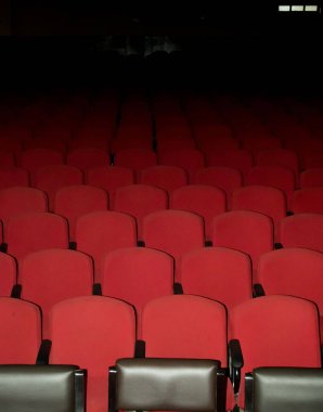 Tiyatroda boş kırmızı sandalyeler. Fotoğraf el feneri kullanılarak çekildi.